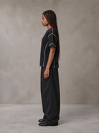 Model wearing SM Sig. Framework T-shirt in Midnight Black, side profile.