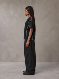 Model wearing SM Sig. Framework T-shirt in Midnight Black, side profile.