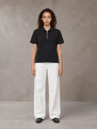 Model wearing SM Sig. Half-Zip Polo Shirt in Midnight Black, front view.