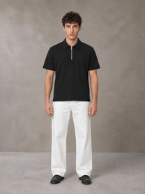 Model wearing SM Sig. Half-Zip Polo Shirt in Midnight Black, front view.