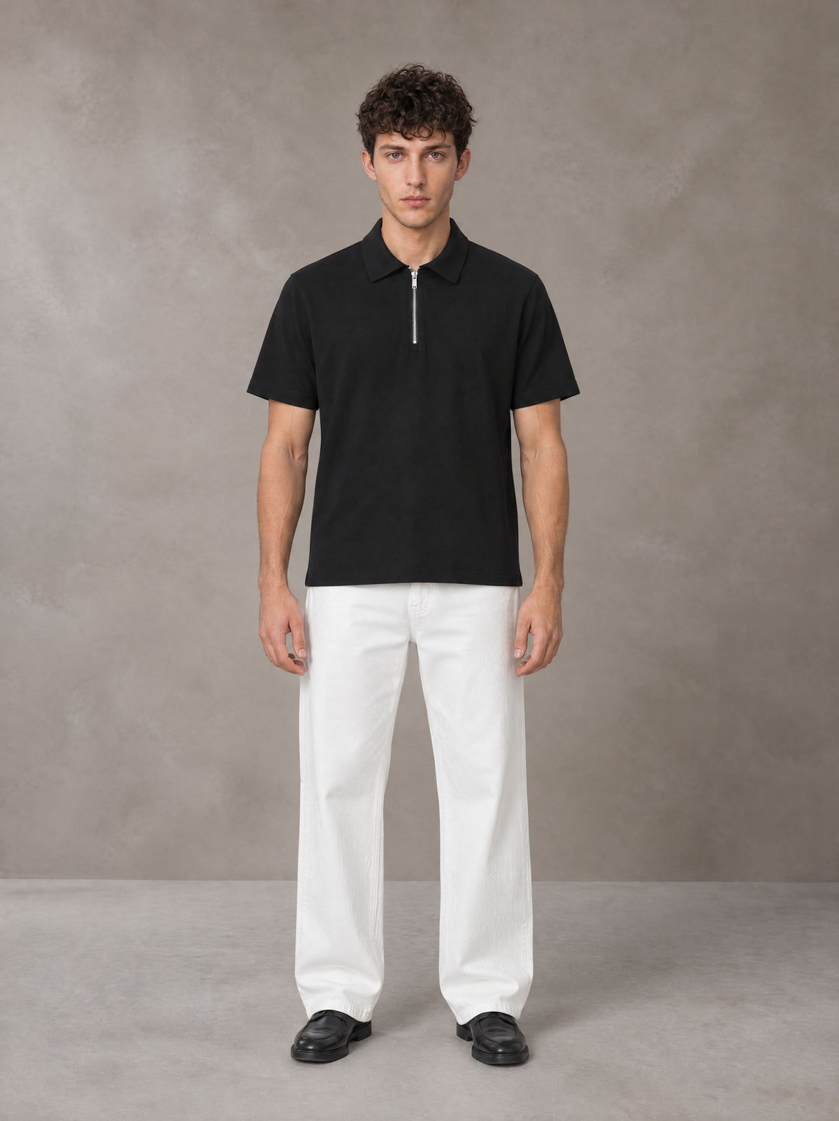 Model wearing SM Sig. Half-Zip Polo Shirt in Midnight Black, front view.