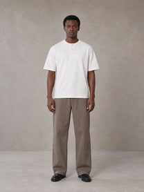 Model wearing SM Sig. Henley T-shirt in Lucent White, front view.