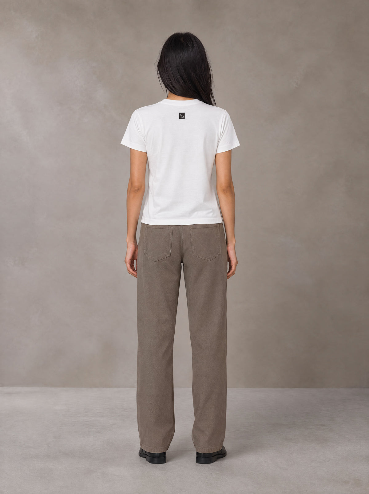 Model wearing SM Sig. Henley T-shirt in Lucent White, rear view.