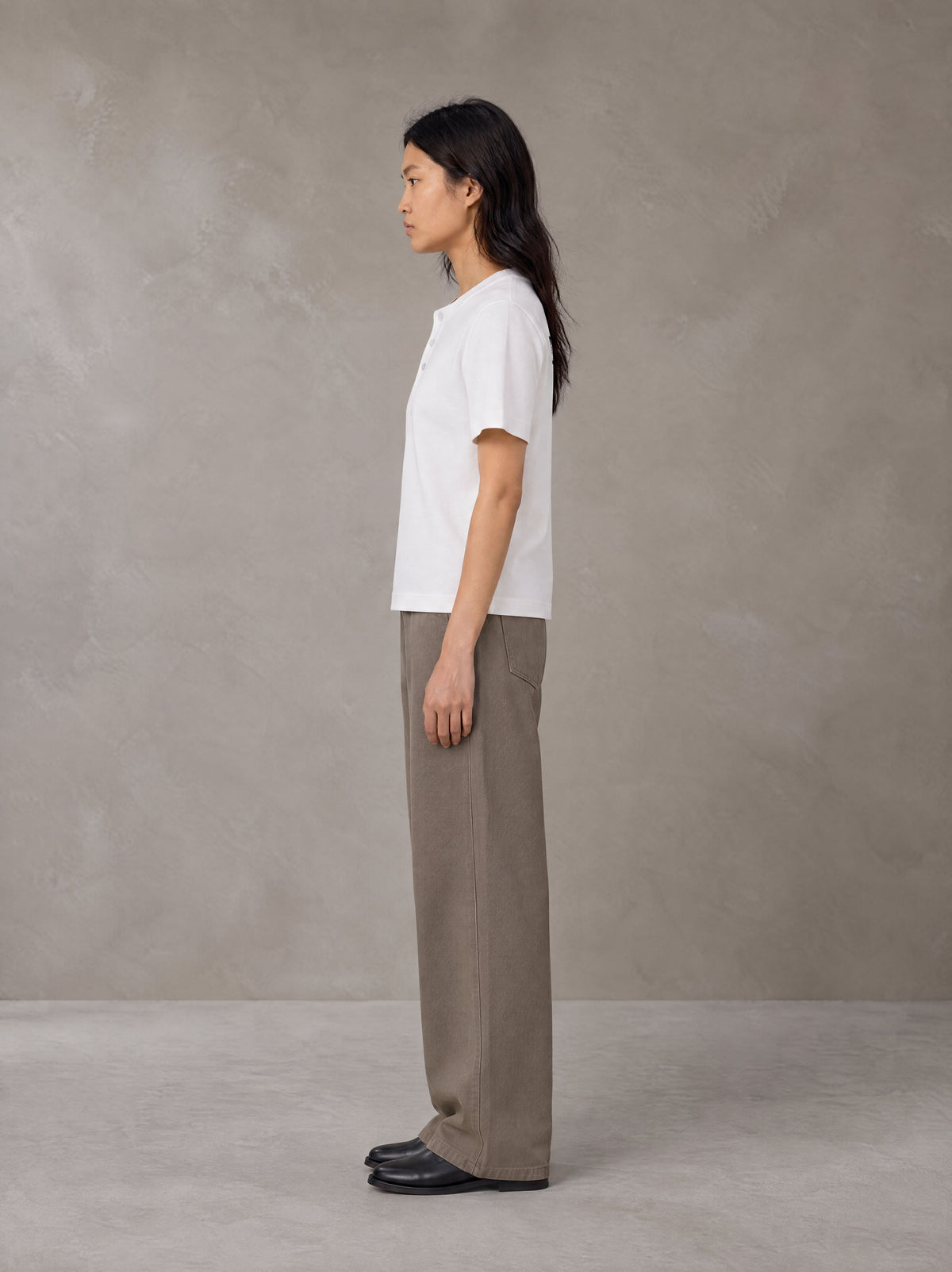 Model wearing SM Sig. Henley T-shirt in Lucent White, side profile.