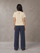 Model wearing SM Sig. Henley T-shirt in Soft Beige, rear view.