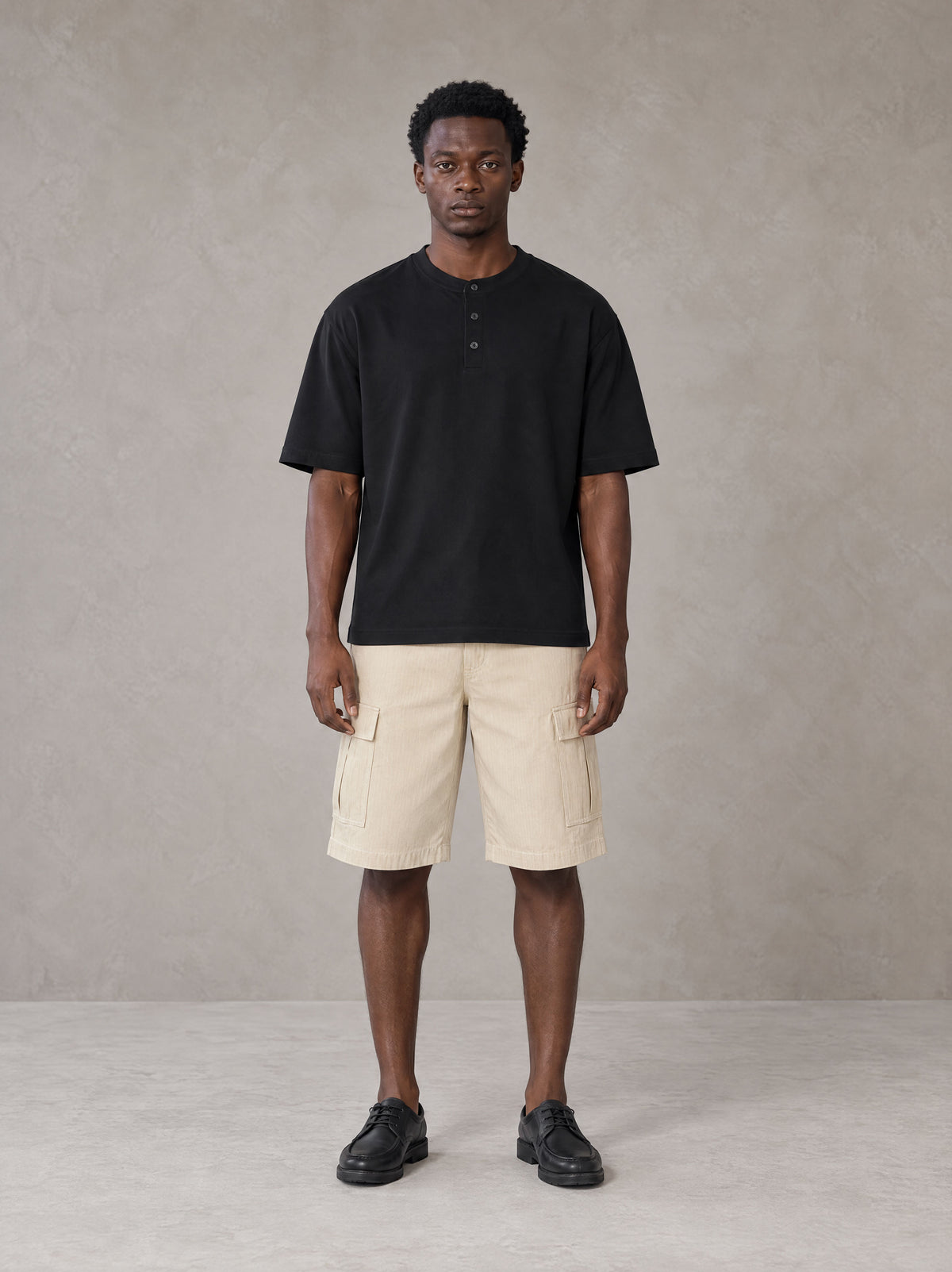 Model wearing SM Sig. Henley T-shirt in Midnight Black, front view.
