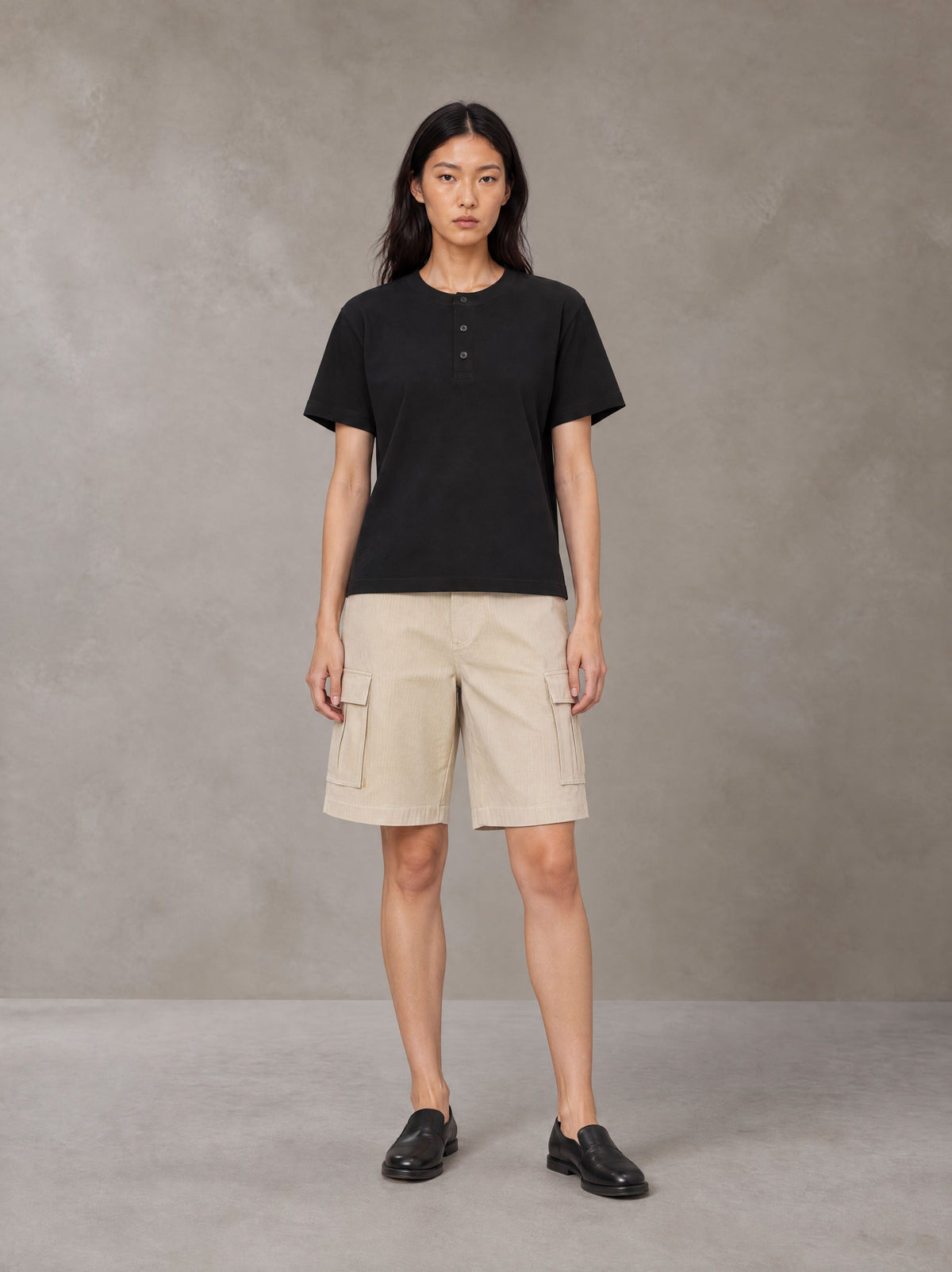 Model wearing SM Sig. Henley T-shirt in Midnight Black, front view.