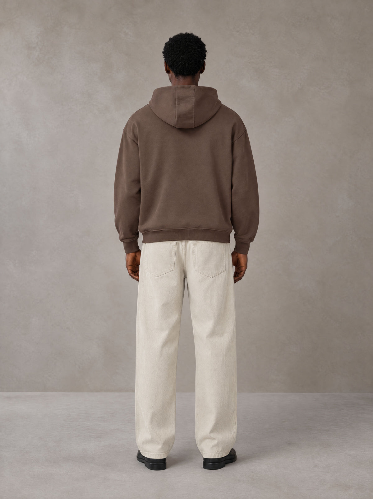 Model wearing SM Sig. High Neck Fleece Hoodie in Brown, rear view.
