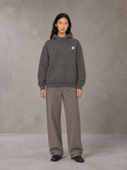 Model wearing SM Sig. High Neck Fleece Hoodie in Deep Charcoal, front view.