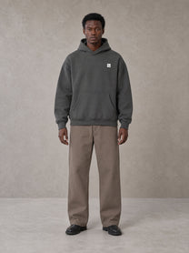 Model wearing SM Sig. High Neck Fleece Hoodie in Deep Charcoal, front view.