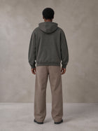Model wearing SM Sig. High Neck Fleece Hoodie in Deep Charcoal, rear view.
