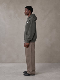Model wearing SM Sig. High Neck Fleece Hoodie in Deep Charcoal, side profile.