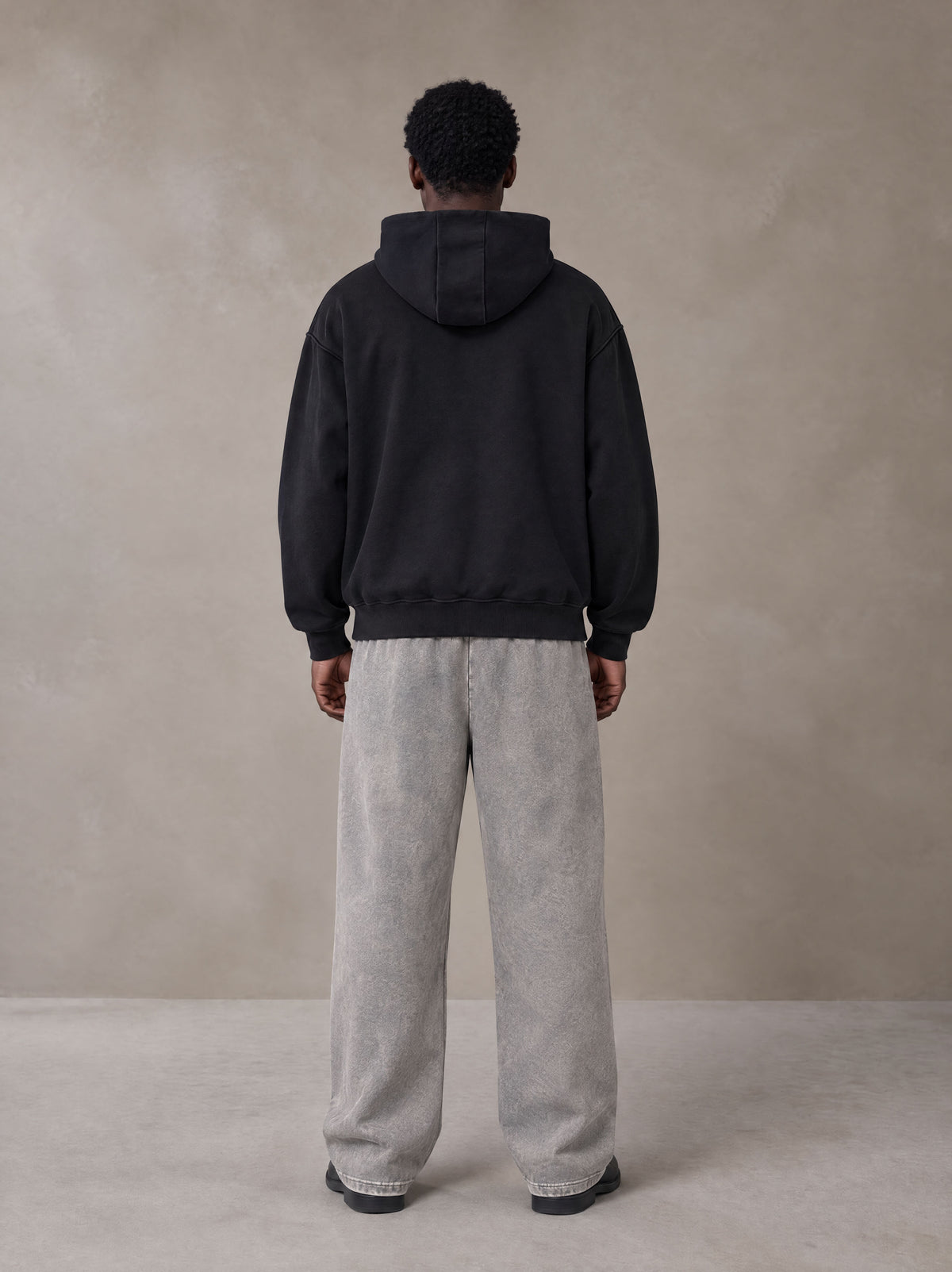 Model wearing SM Sig. High Neck Fleece Hoodie in Midnight Black, rear view.