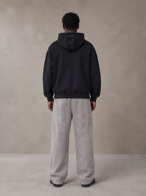 Model wearing SM Sig. High Neck Fleece Hoodie in Midnight Black, rear view.
