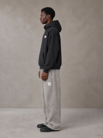 Model wearing SM Sig. High Neck Fleece Hoodie in Midnight Black, side profile.