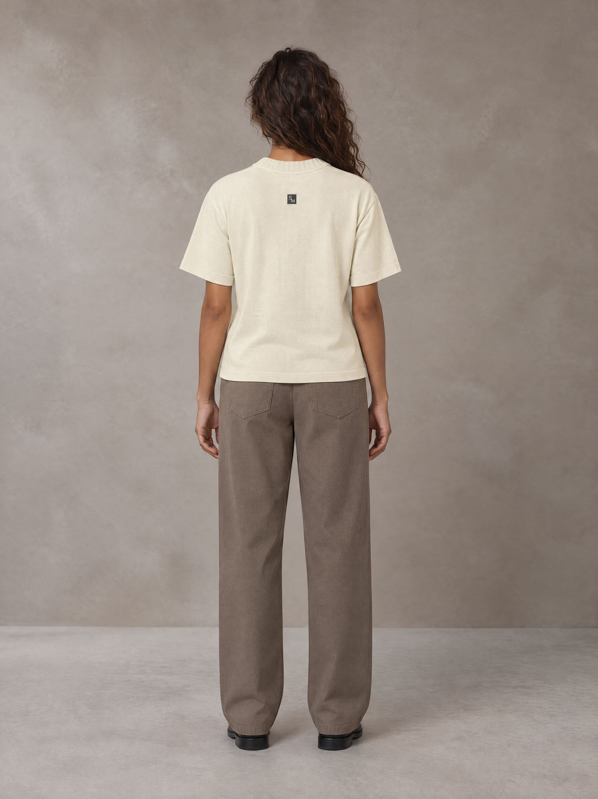 Model wearing SM Sig. Knitted Round Neck T-shirt in Neutral Heather, rear view.