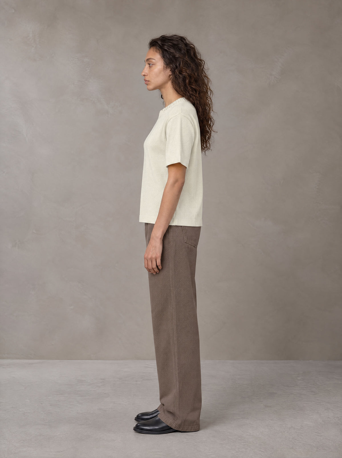 Model wearing SM Sig. Knitted Round Neck T-shirt in Neutral Heather, side profile.