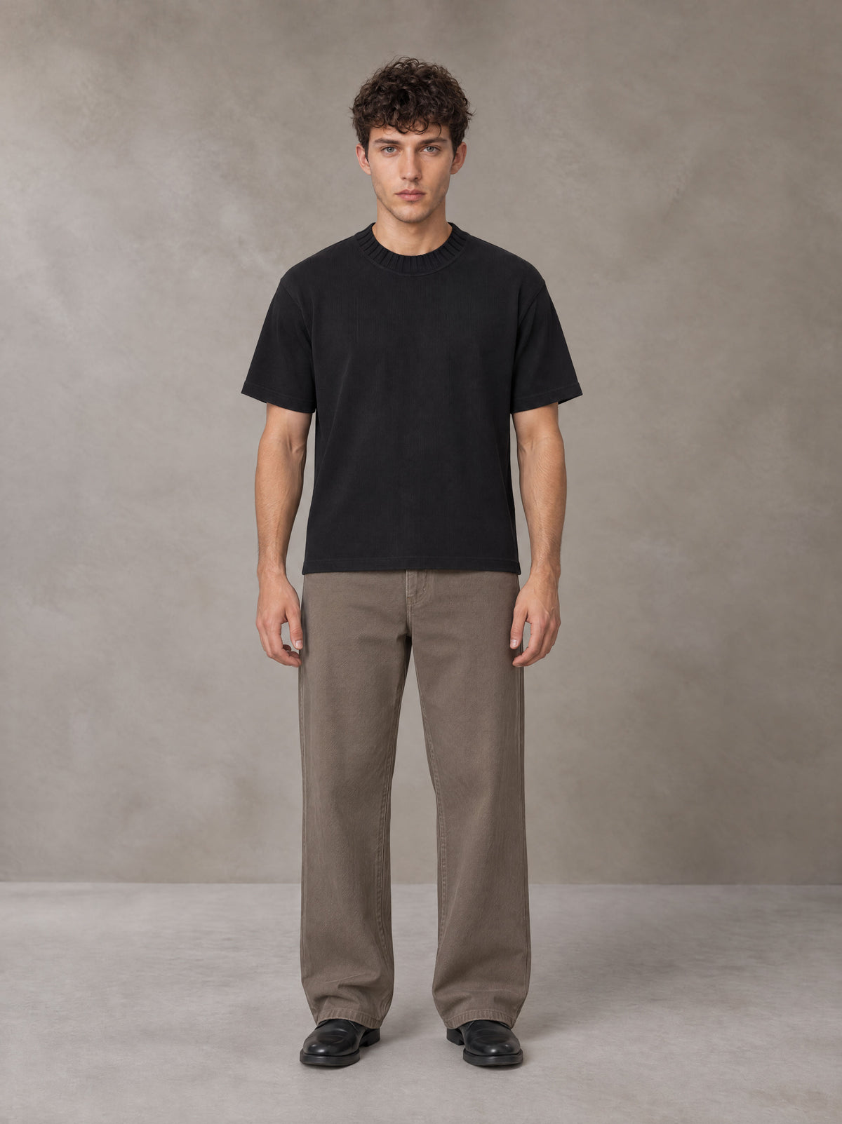 Model wearing SM Sig. Knitted Round Neck T-shirt in Midnight Black, front view.