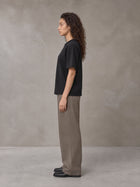 Model wearing SM Sig. Knitted Round Neck T-shirt in Midnight Black, side profile.