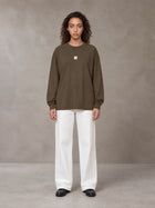 Model wearing SM Sig. Long Sleeve T-shirt in Brown, front view.