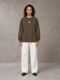 Model wearing SM Sig. Long Sleeve T-shirt in Brown, front view.