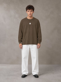 Model wearing SM Sig. Long Sleeve T-shirt in Brown, front view.