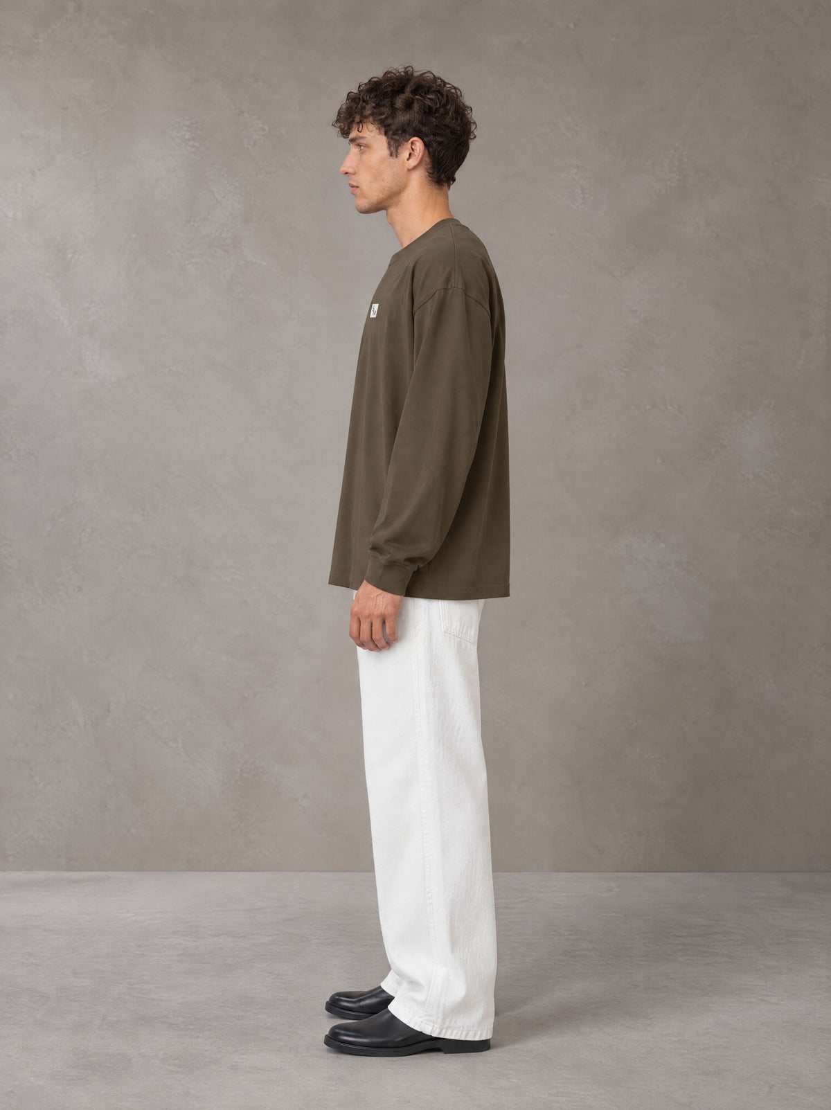 Model wearing SM Sig. Long Sleeve T-shirt in Brown, side profile.