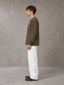 Model wearing SM Sig. Long Sleeve T-shirt in Brown, side profile.