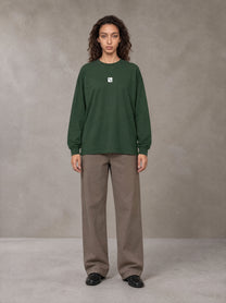 Model wearing SM Sig. Long Sleeve T-shirt in Dark Green, front view.