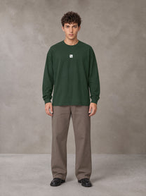 Model wearing SM Sig. Long Sleeve T-shirt in Dark Green, front view.