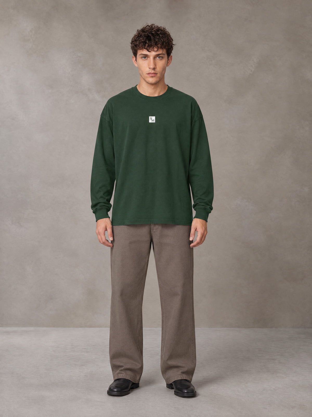 Model wearing SM Sig. Long Sleeve T-shirt in Dark Green, front view.