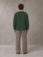 Model wearing SM Sig. Long Sleeve T-shirt in Dark Green, rear view.