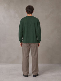 Model wearing SM Sig. Long Sleeve T-shirt in Dark Green, rear view.