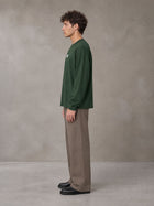 Model wearing SM Sig. Long Sleeve T-shirt in Dark Green, side profile.