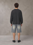 Model wearing SM Sig. Long Sleeve T-shirt in Deep Charcoal, rear view.