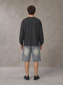 Model wearing SM Sig. Long Sleeve T-shirt in Deep Charcoal, rear view.