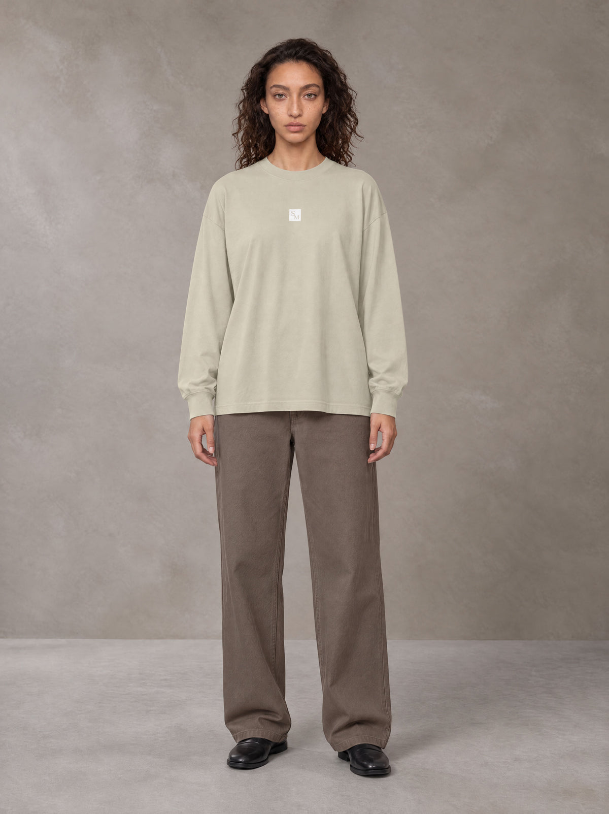 Model wearing SM Sig. Long Sleeve T-shirt in Fine Sand, front view.