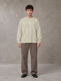 Model wearing SM Sig. Long Sleeve T-shirt in Fine Sand, front view.