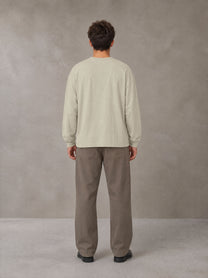 Model wearing SM Sig. Long Sleeve T-shirt in Fine Sand, rear view.