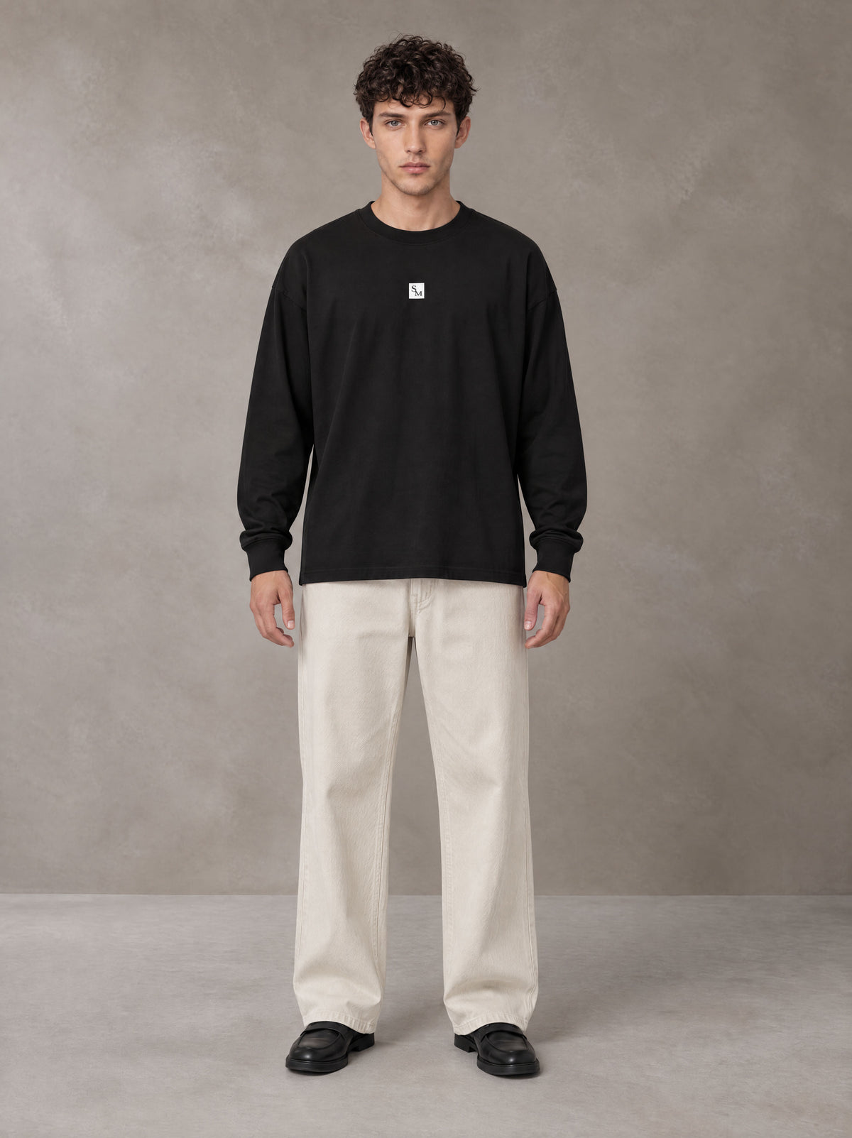 Model wearing SM Sig. Long Sleeve T-shirt in Midnight Black, front view.