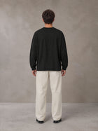 Model wearing SM Sig. Long Sleeve T-shirt in Midnight Black, rear view.