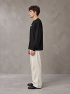 Model wearing SM Sig. Long Sleeve T-shirt in Midnight Black, side profile.