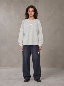 Model wearing SM Sig. Long Sleeve T-shirt in Pure Grey, front view.