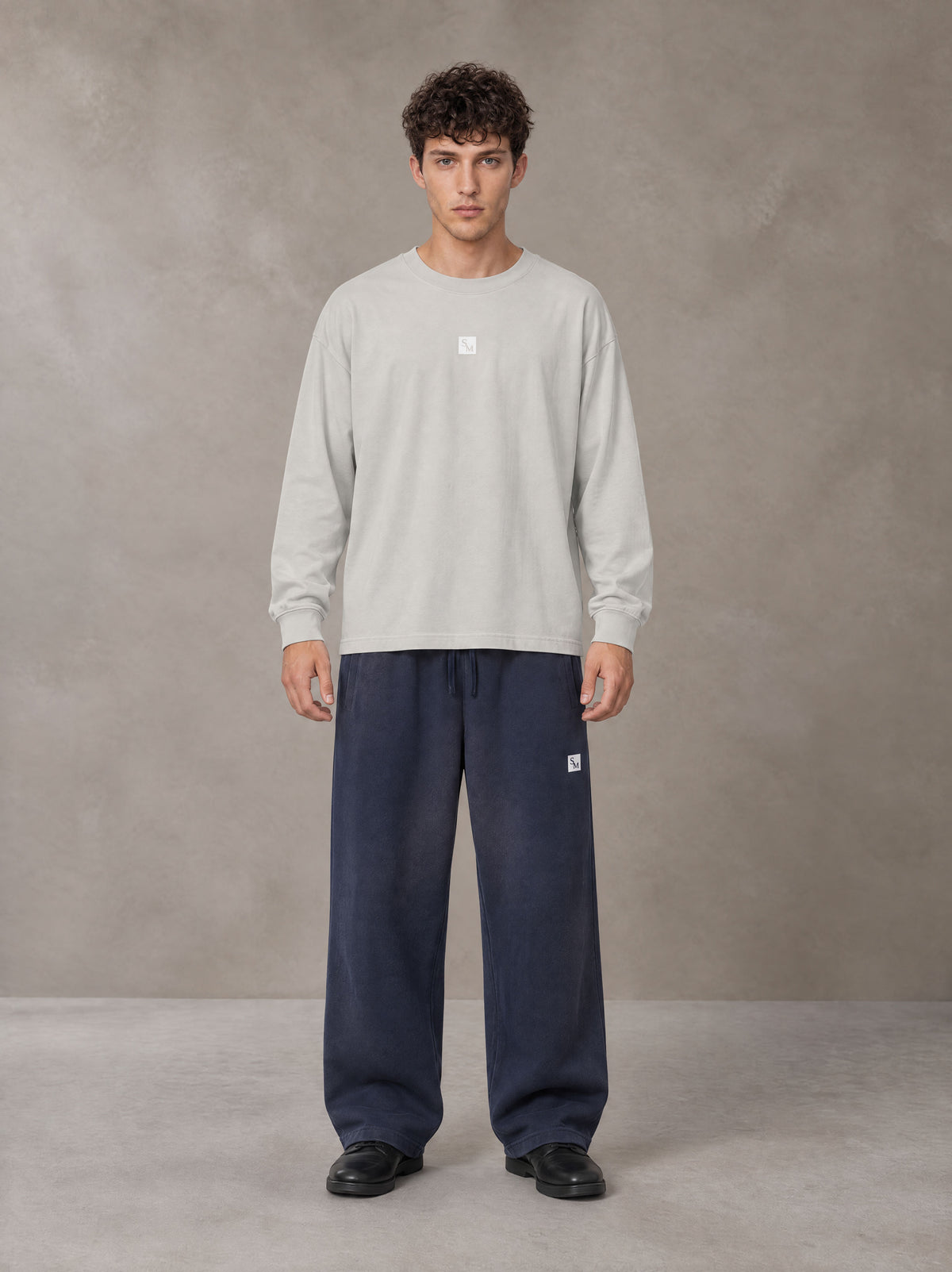Model wearing SM Sig. Long Sleeve T-shirt in Pure Grey, front view.