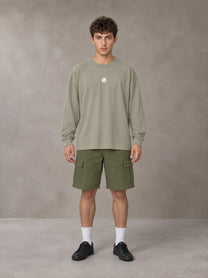 Model wearing SM Sig. Long Sleeve T-shirt in Stone Grey, front view.