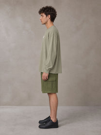 Model wearing SM Sig. Long Sleeve T-shirt in Stone Grey, side profile.