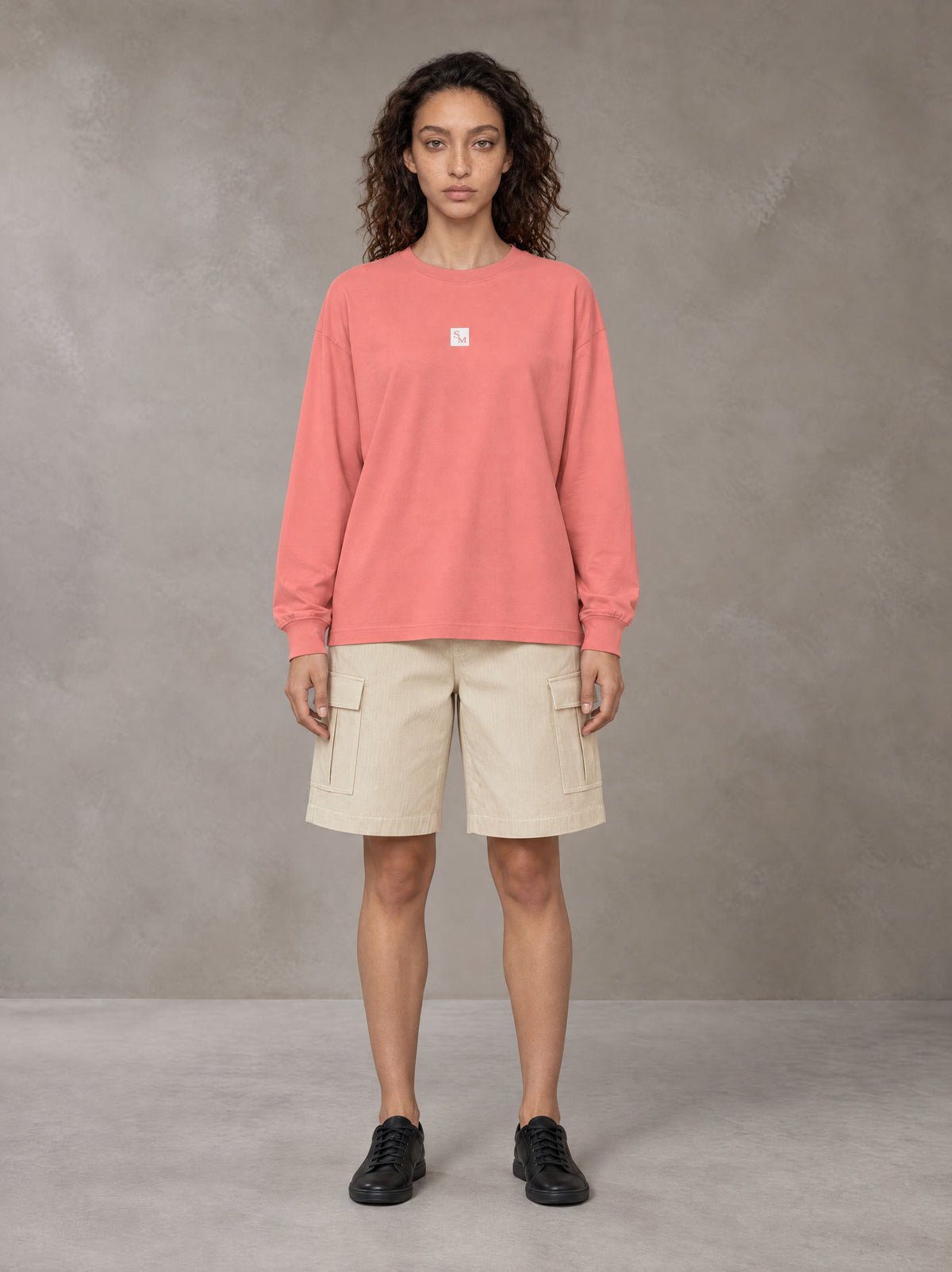Model wearing SM Sig. Long Sleeve T-shirt in Watermelon Tint, front view.