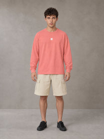 Model wearing SM Sig. Long Sleeve T-shirt in Watermelon Tint, front view.