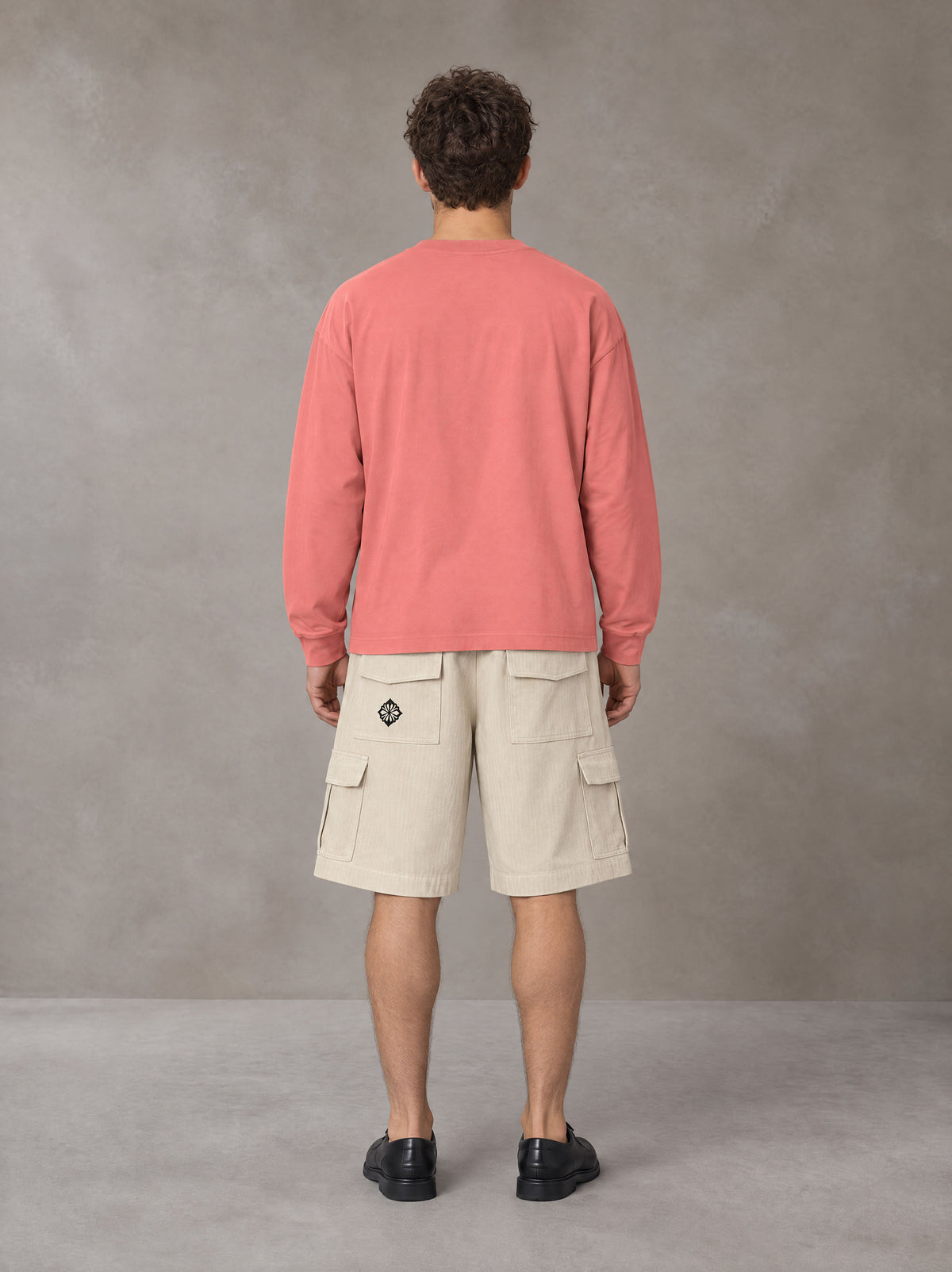 Model wearing SM Sig. Long Sleeve T-shirt in Watermelon Tint, rear view.