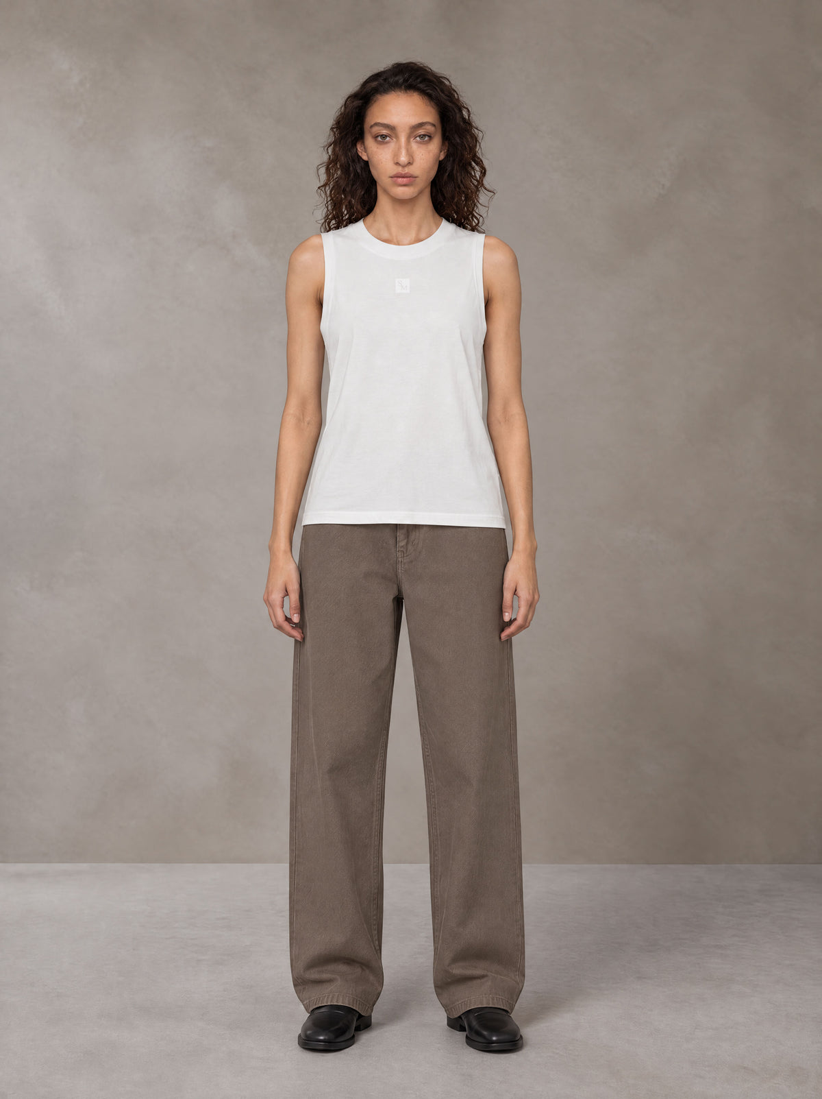 Model wearing SM Sig. Sleeveless Tank Top in Ivory White, front view.